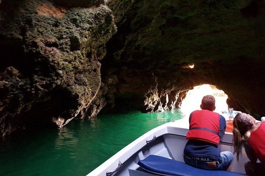 A boat navigating through a narrow waterway with rocky cliffs on either side. 3