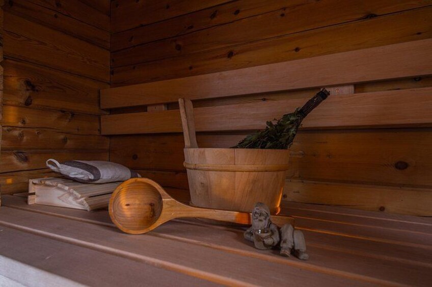 A wooden interior with a wooden spoon, a small figurine, and a basket with herbs. 1