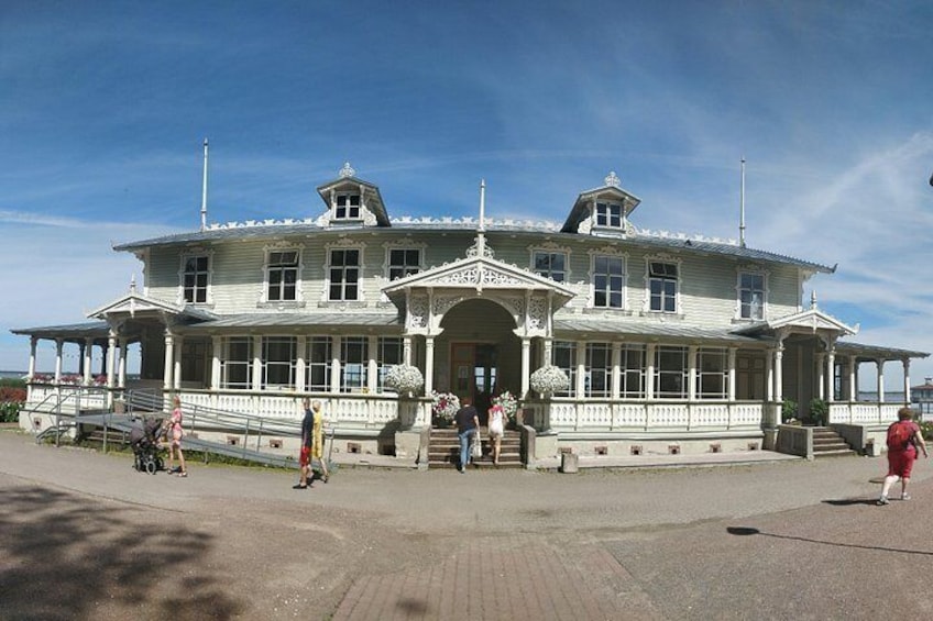 Ein großes, weißes Gebäude mit einer Veranda und Stufen, die zu ihm hinaufführen. 2