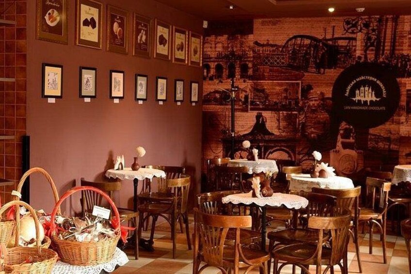 Un interior de restaurante con mesas de madera, cestas de mimbre y cuadros en la pared. 1