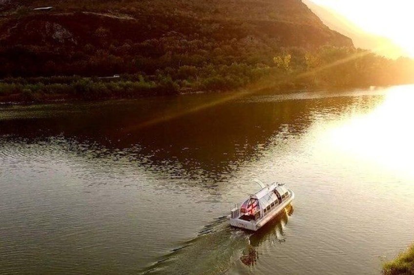 Un barco en un río tranquilo con un paisaje montañoso al fondo. 2