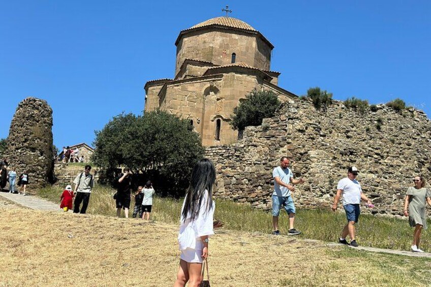 Un edificio histórico con una cúpula, rodeado de un área verde con gente caminando. 3
