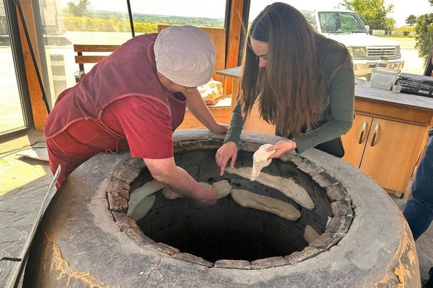 Dos personas trabajando con un horno de piedra grande y redondo. 3