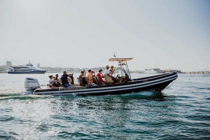Un bateau avec des personnes à bord, naviguant sur l’eau, avec une vue sur la ville en arrière-plan. 4