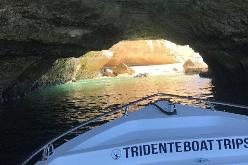Un bateau sur lequel on peut lire les mots « TRIDENTEBOAT TRIPS » sur le côté, naviguant dans une grotte dont les parois sont recouvertes d’eau. 4