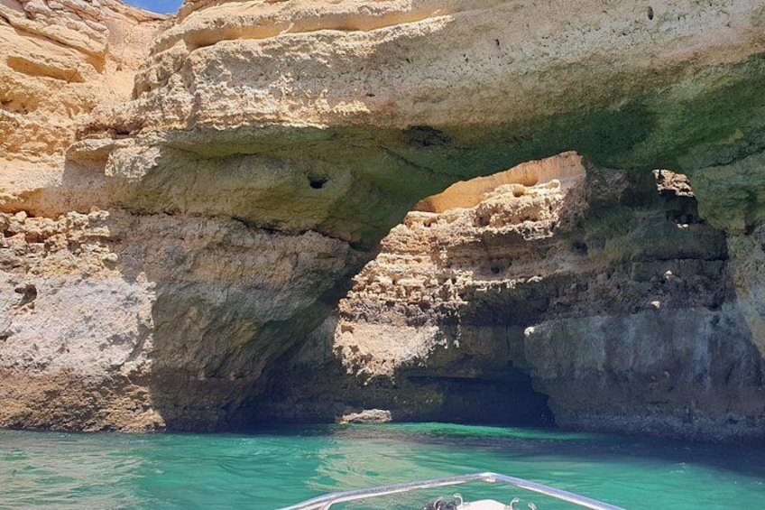 Une arche naturelle formée par la roche, surplombant une eau turquoise. 5