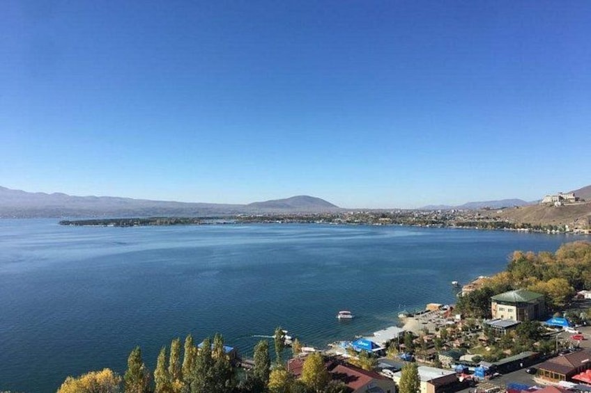 A lake with a small town on the shore, clear skies, and distant mountains. 3