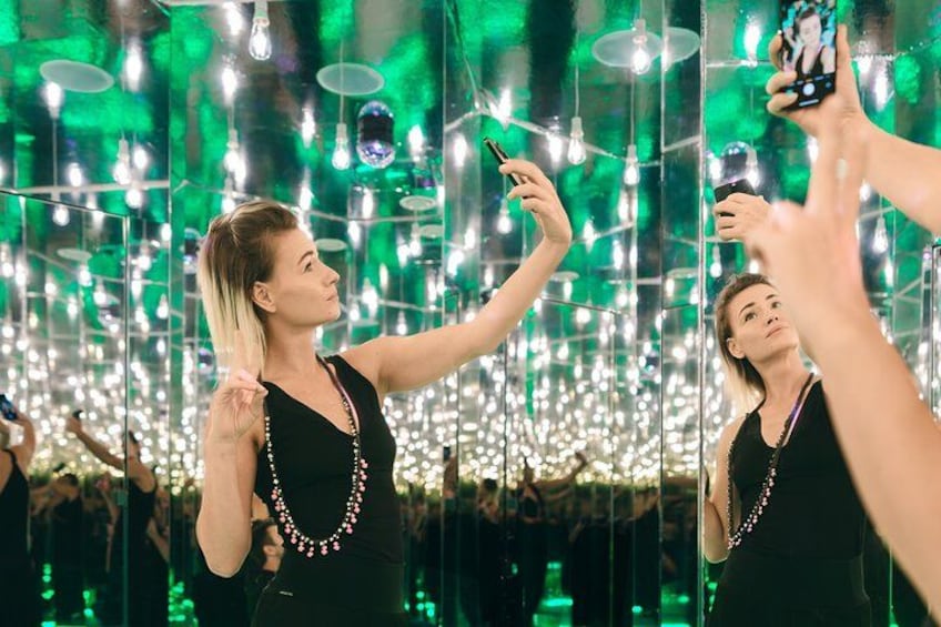 Eine Person macht ein Selfie in einem Raum mit hängenden Glühbirnen. 5