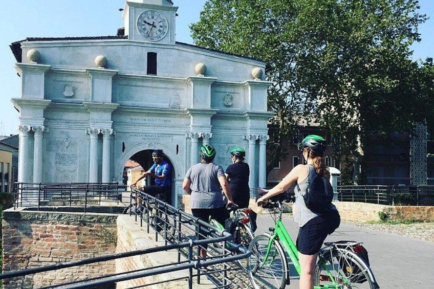 En historisk bygning med et tårn, en bro og cyklister. 4