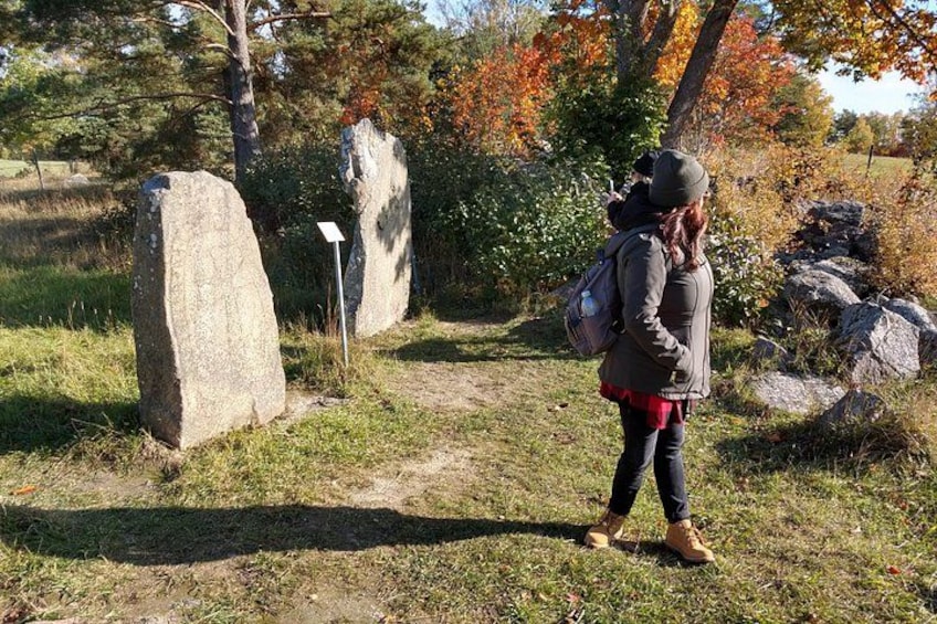 Una persona che cammina su un sentiero tra grandi massi e alberi con foglie autunnali. 3
