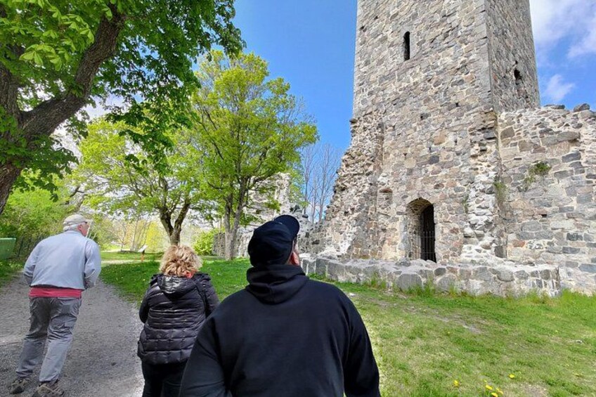 A stone tower, a paved path, and green trees. 5
