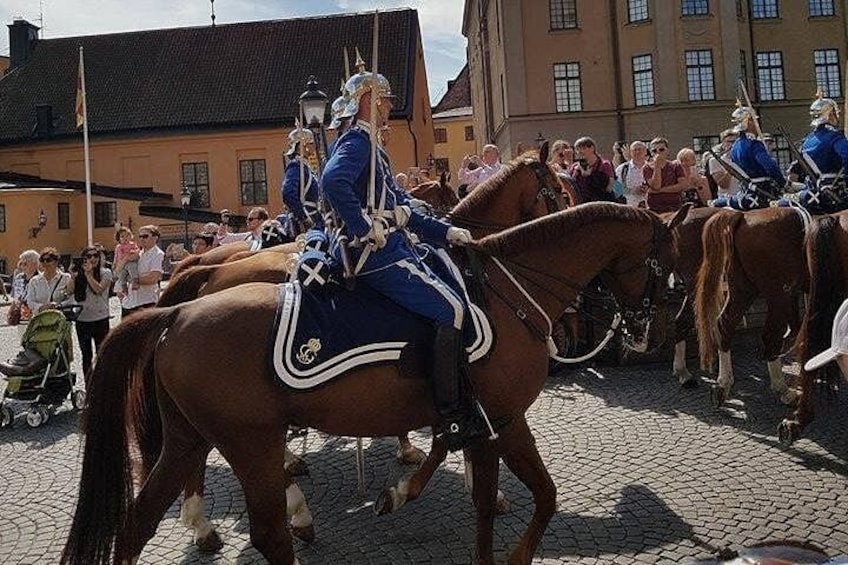 A person riding a horse in a cobblestone street, with buildings in the background. 4