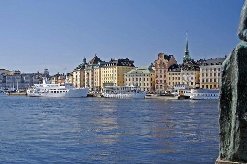 A harbor with several cruise ships docked, a prominent church steeple, and historic buildings along the waterfront. 5