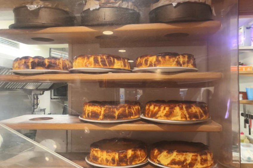 A bakery display with several cakes on shelves. 3
