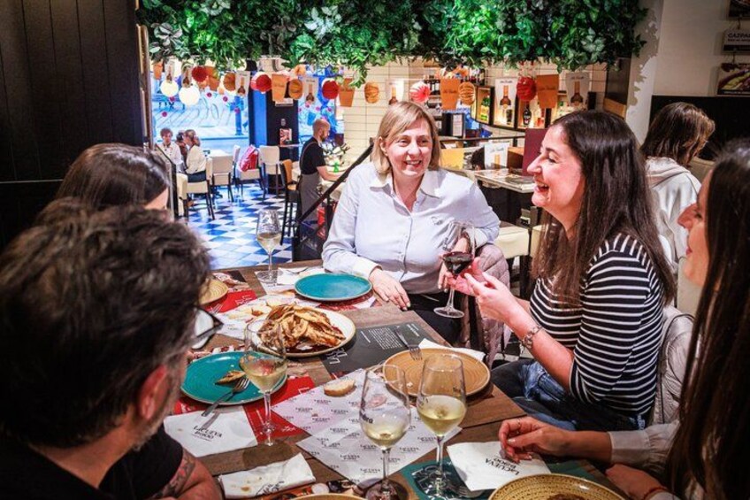 A group of people dining at a restaurant with a checkered floor and a bar in the background. 4