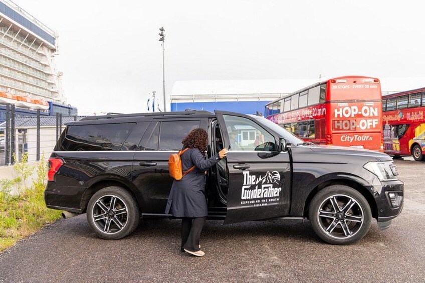 A black SUV with 'The Guidefather' logo parked on a road. 2