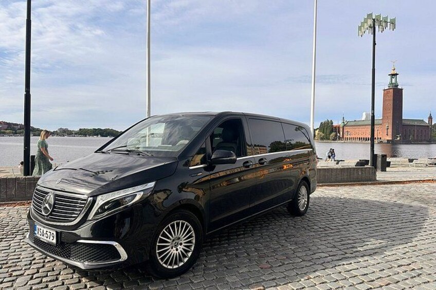 Ein schwarzer Mercedes-Benz Van steht an einem Kopfsteinpflaster-Wasserufer. 2