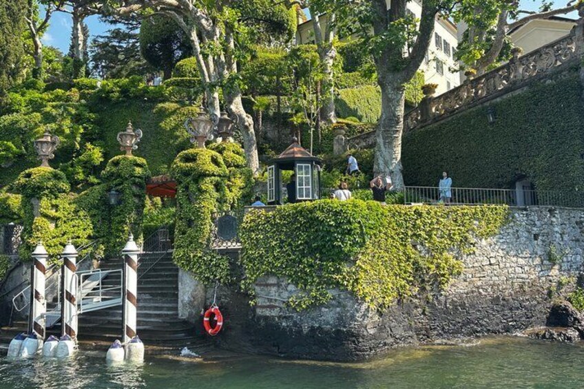 A stone bridge over water, a small island with a gazebo, and a stone wall with greenery. 4