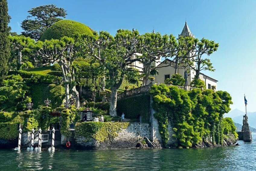 A landscaped island with a building, trees, and a statue. 3