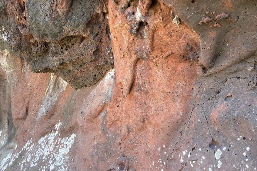 A close-up of a rocky surface with visible erosion patterns and mineral deposits. 3