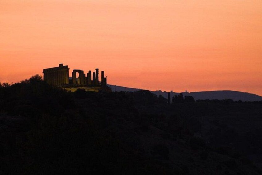 A historical ruin silhouetted against a sunset sky. 2