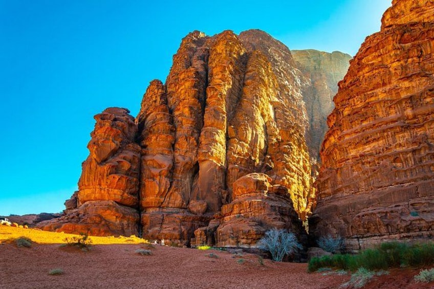 A rock formation with layered strata and a clear blue sky. 1