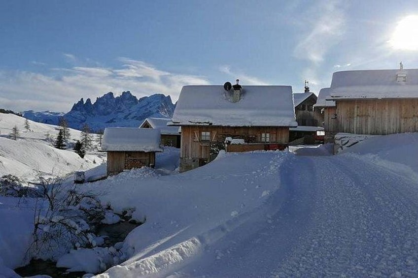 Un pueblo montañoso nevado con casas de madera y cielo despejado. 1
