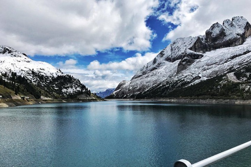 Un lago tranquilo rodeado de montañas nevadas bajo un cielo parcialmente nublado. 3