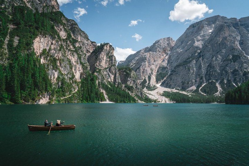 Un lago tranquilo rodeado de montañas, una lancha con dos personas y cielos despejados. 4