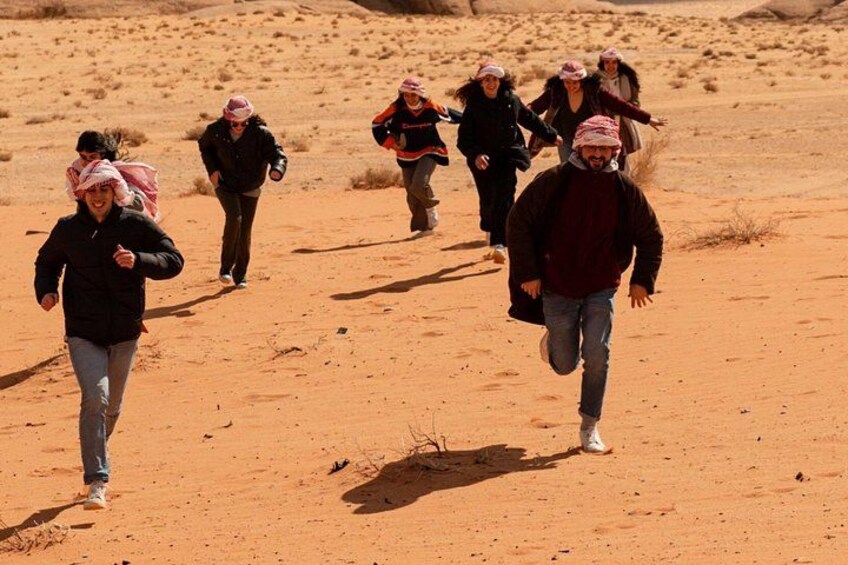 A group of people running in a desert landscape. 1