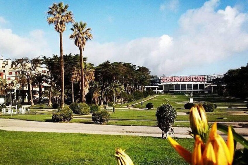 A park with palm trees, a statue, and a building labeled 'CASINO ESTORIA' in the background. 3