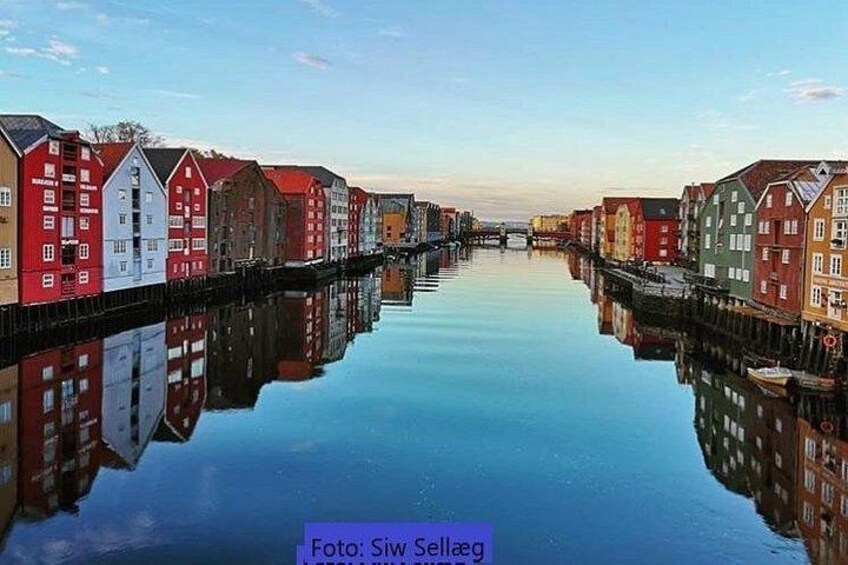 A canal with colorful buildings reflecting on the water. 1