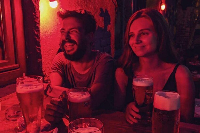 Två personer sitter vid ett bord med flera ölglas. 1