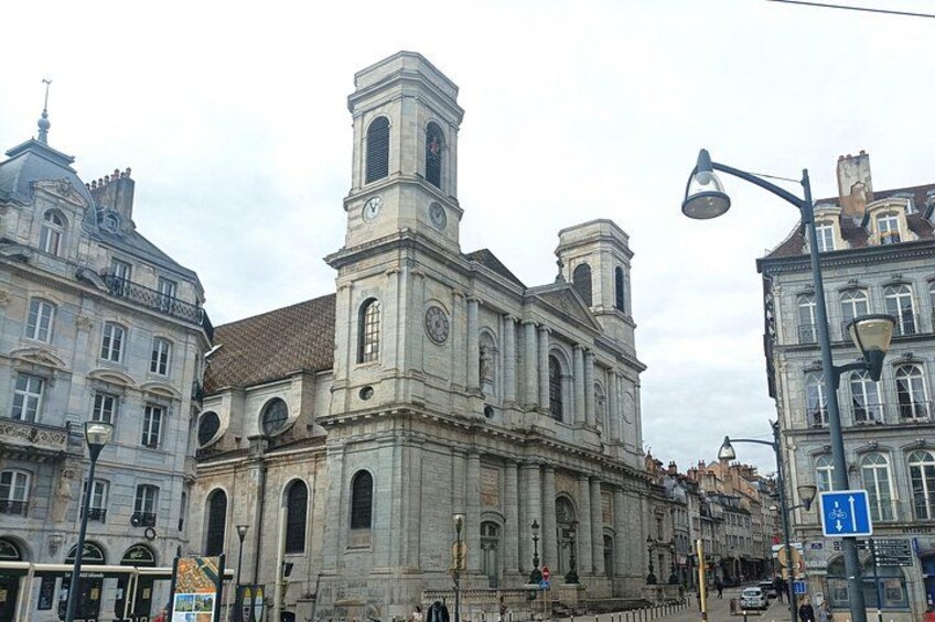 A historic building with a clock tower, surrounded by other classical architecture. 2
