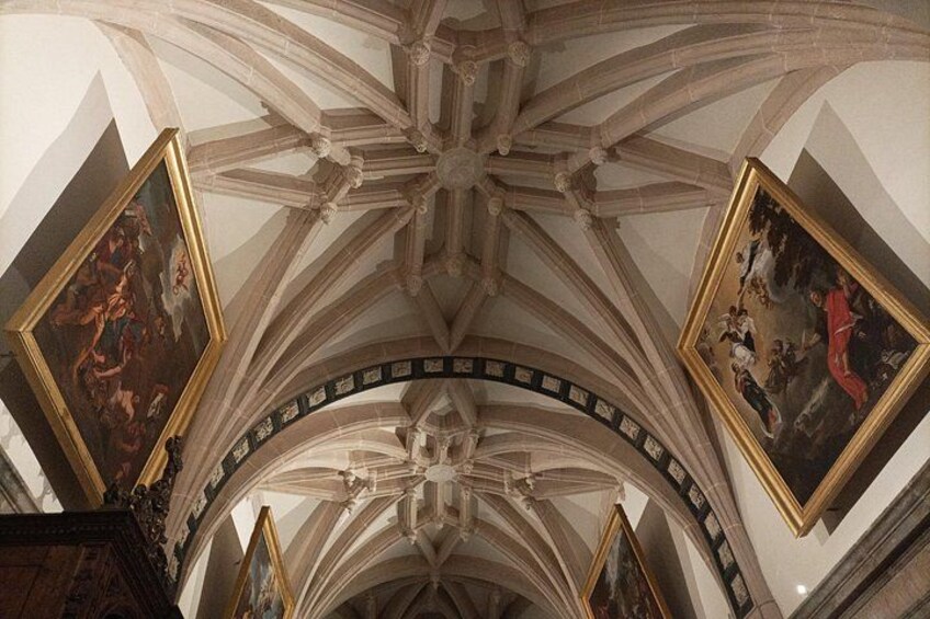 A cathedral interior with ribbed vaults, pointed arches, and frescoes. 4