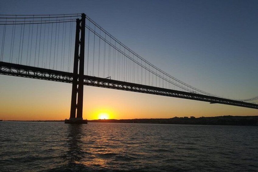 A suspension bridge at sunset with the sun setting behind it. 4