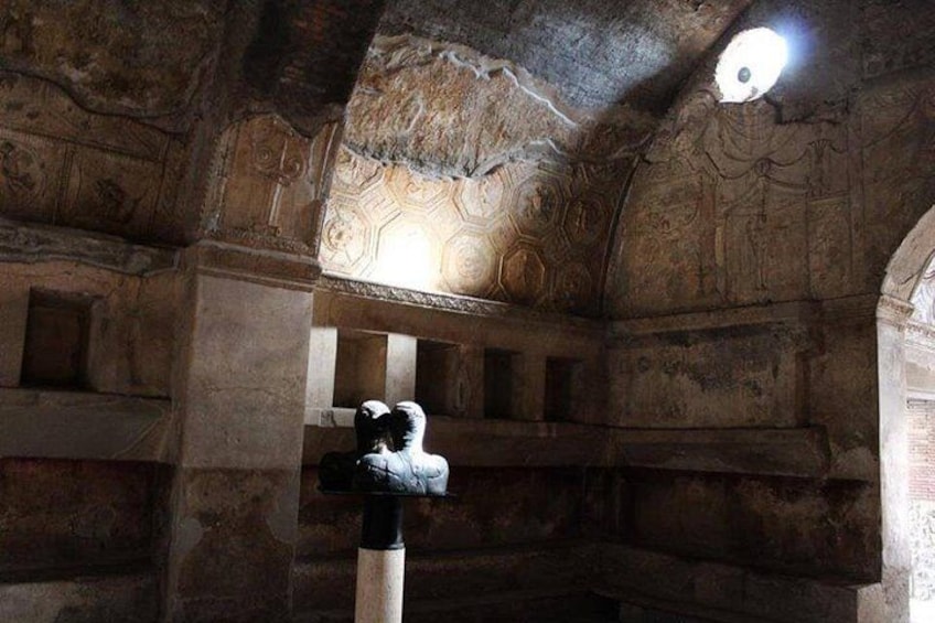 An ancient stone structure with carved walls and a central pillar. 5
