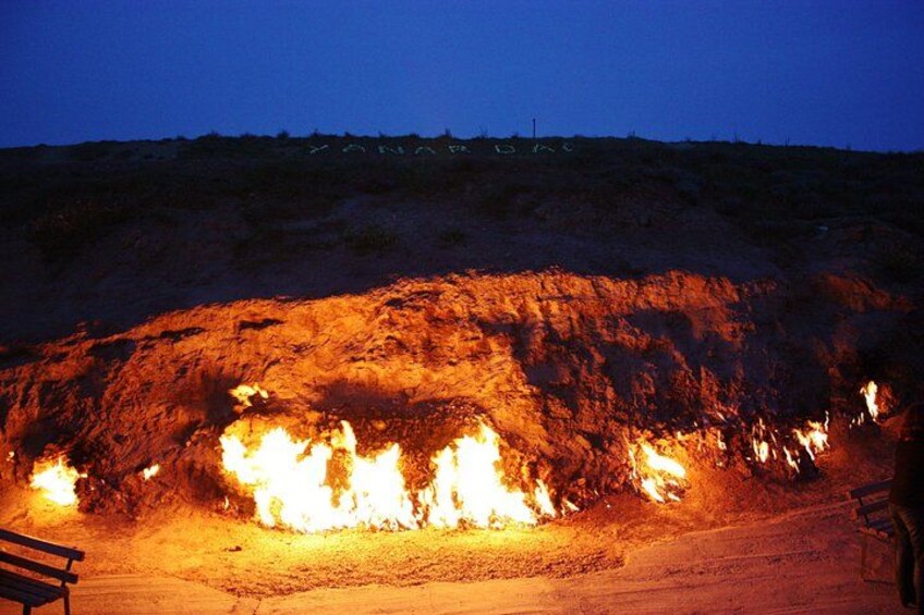 Un grand feu qui brûle dans un terrain rocheux, la nuit. 2
