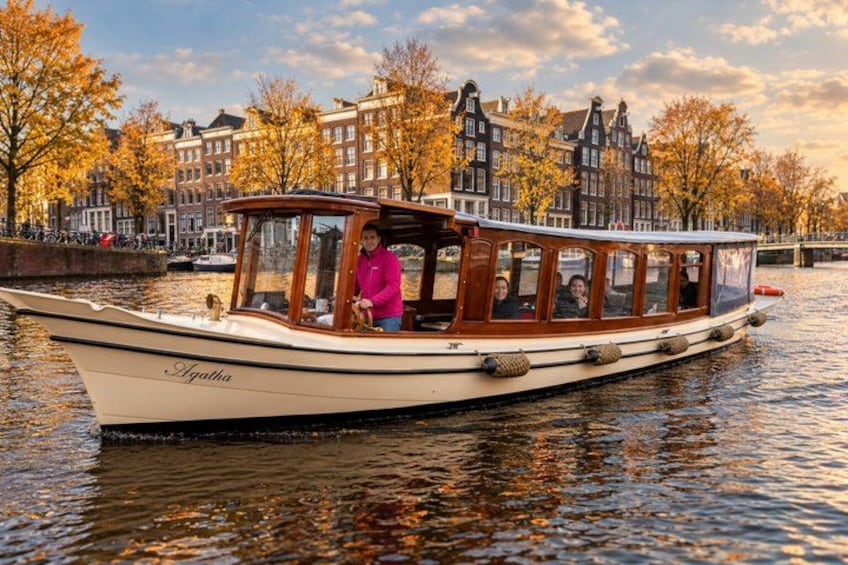 A boat named Agatha on a canal with autumn trees and historic buildings in the background. 5