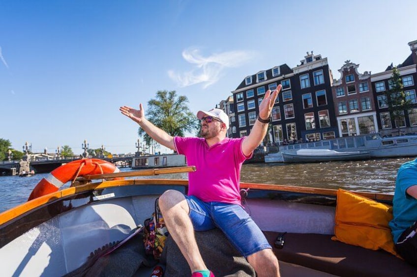 A man in a boat with arms raised, a cityscape with historic buildings in the background, and a calm river. 2