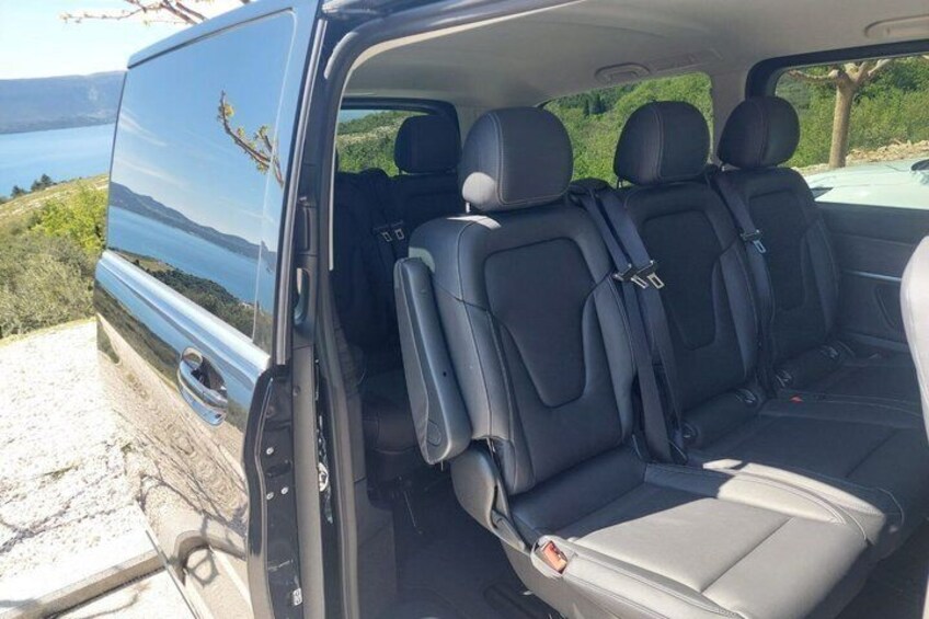 A blue van with black interior seats and a visible rearview mirror. 4