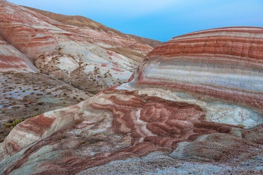 Layered rock formations with visible striations and erosion patterns. 1