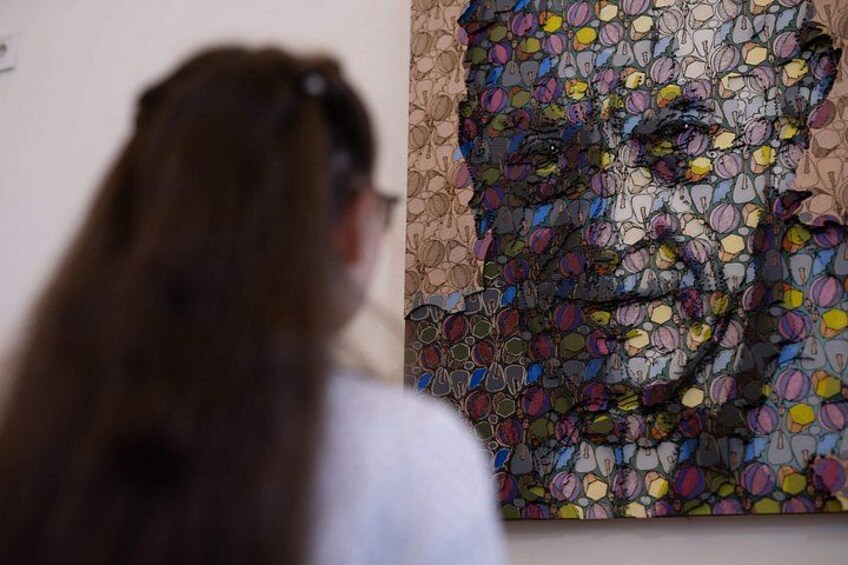 Una persona observa un colorido mural de mosaicos. 2