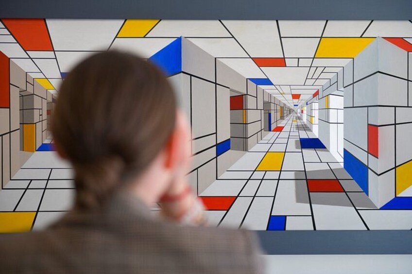 Una persona observando un patrón geométrico colorido en una pared. 3
