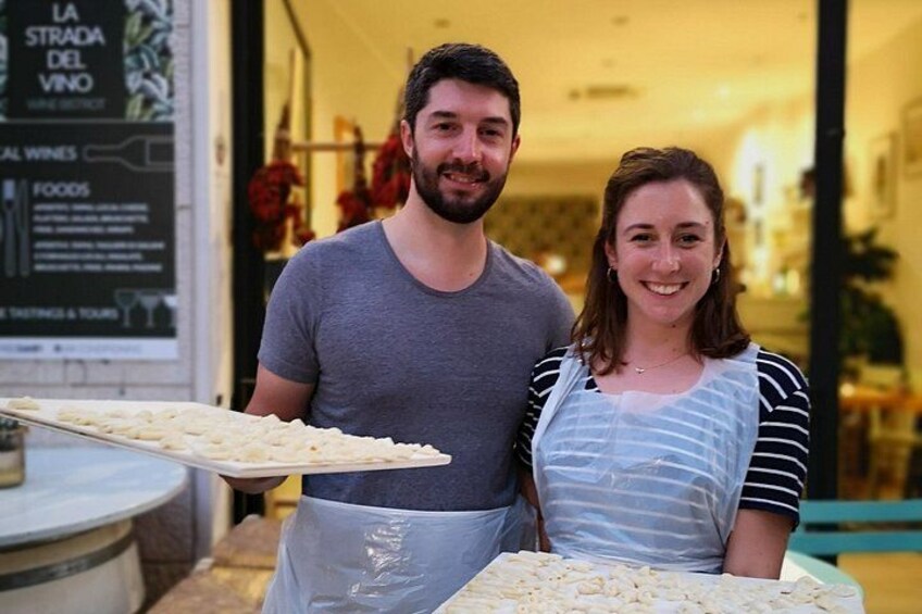 Two people standing in front of a counter with food items. 5