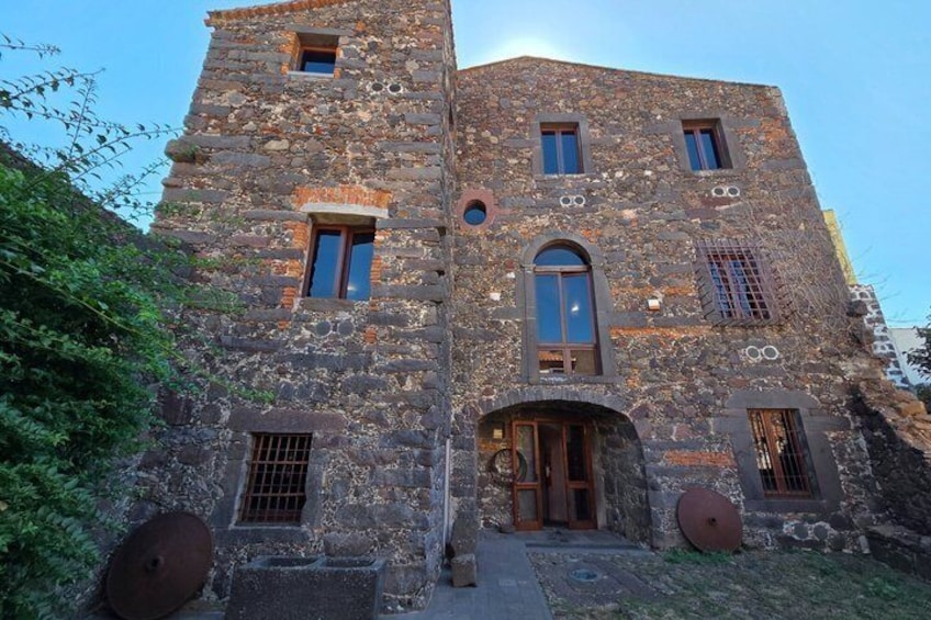 A stone building with arched windows and a door. 3