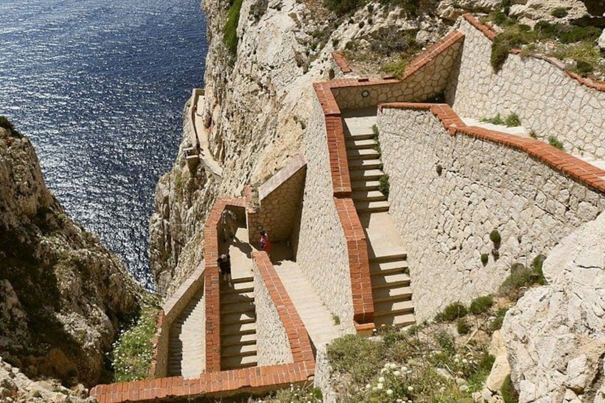 A stone staircase descending a steep cliffside, overlooking a body of water. 2