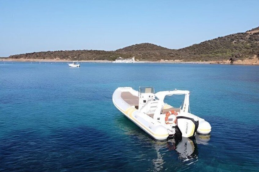A small motorboat on calm water with a clear sky and hills in the background. 3