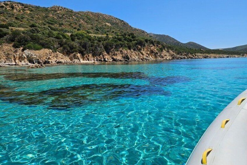 Clear turquoise water, a boat, and a hilly landscape. 4