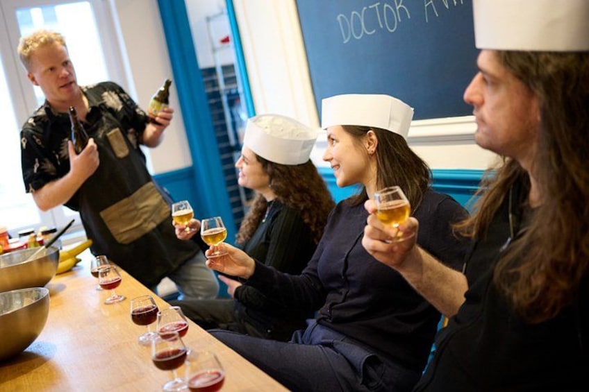Un groupe de personnes portant des toques de chef, tenant des verres de vin, et une personne versant du vin dans un verre. 2